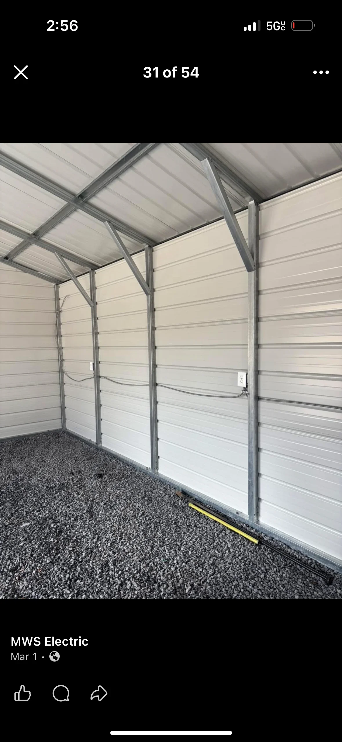 Interior garage with white sectional doors, metal framing, and installed electrical conduit and wiring